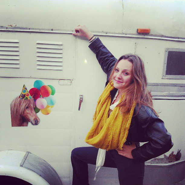 Olivia standing by a white vehicle wearing a yellow scarf, from the 2014 Upbeat post