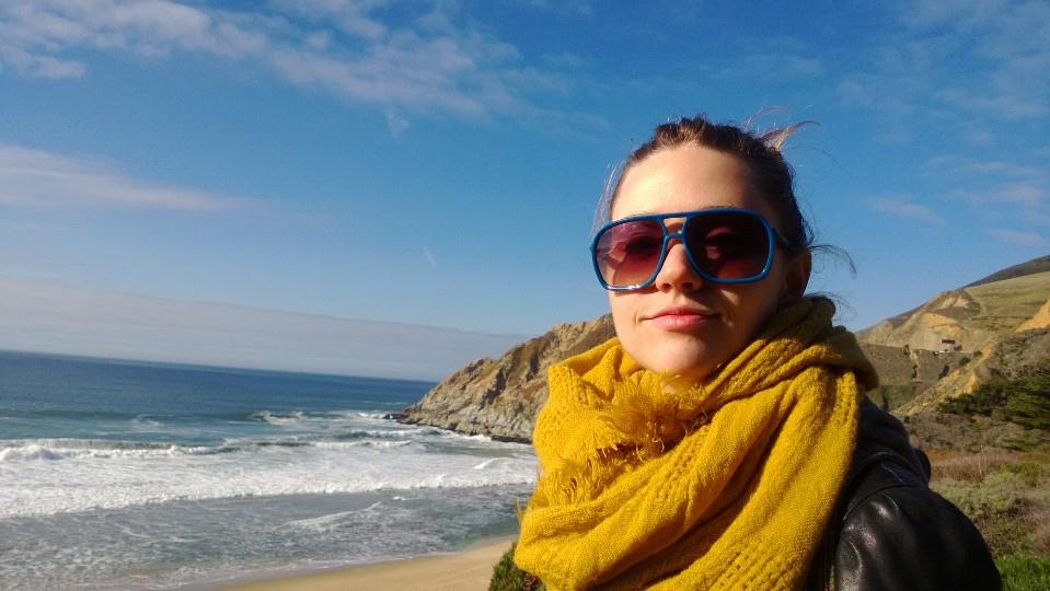 Olivia at the coast wearing sunglasses and a yellow scarf, from the 2014 Inspiration post